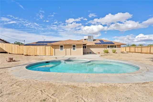 a view of swimming pool with a yard and fence