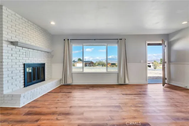 a view of empty room with wooden floor and fireplace