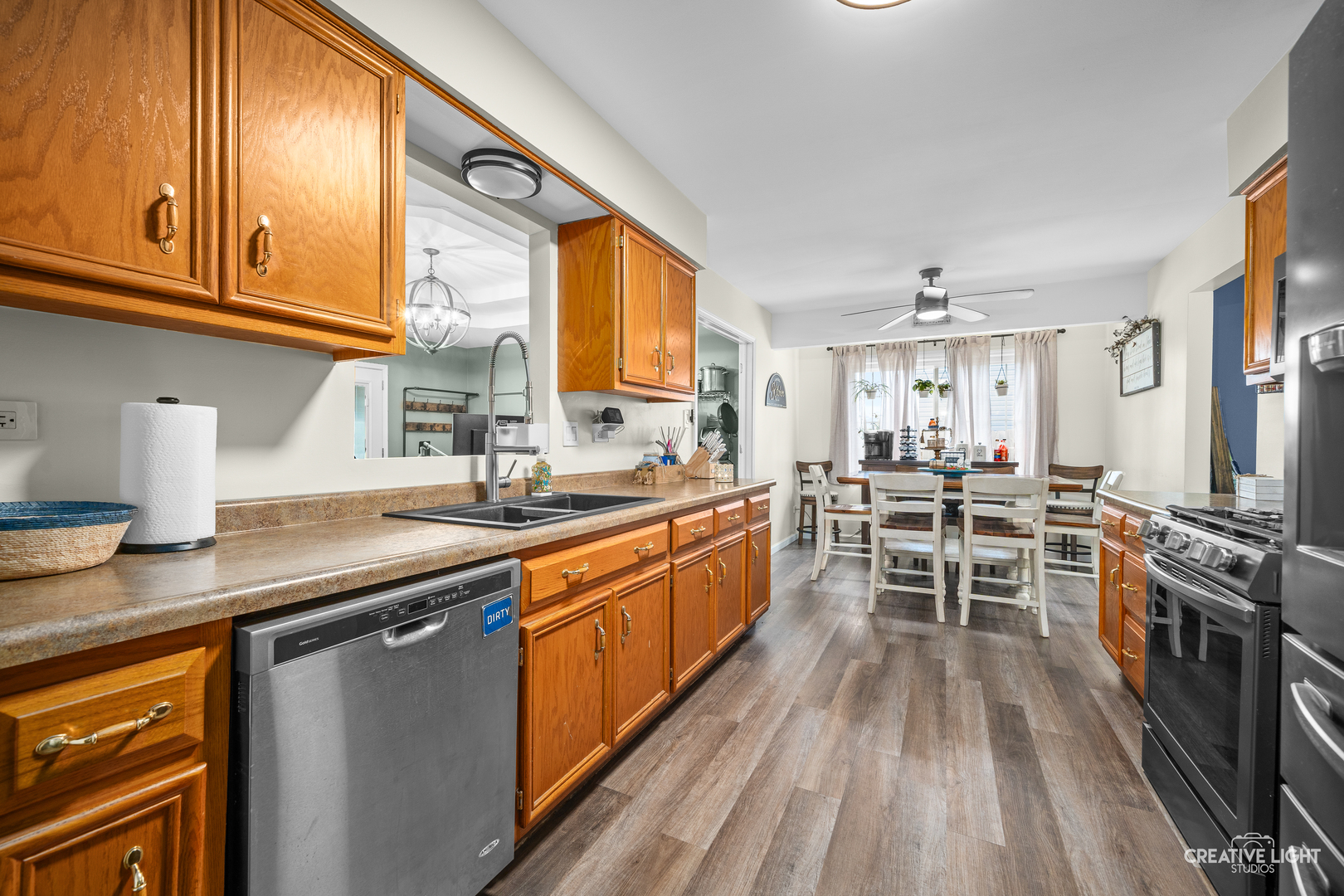 3000 Art Schultz Drive Plainfield, IL 60586 - Photo 6 of 18 a kitchen with stainless steel appliances granite countertop a stove top oven a sink dishwasher a dining table and chairs with wooden floor