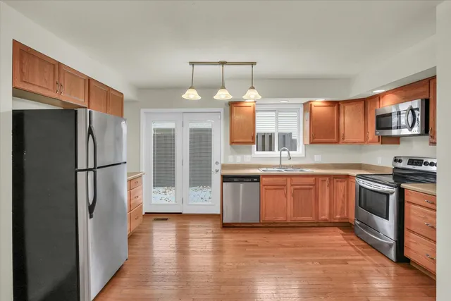 a kitchen with stainless steel appliances granite countertop a refrigerator stove top oven and sink