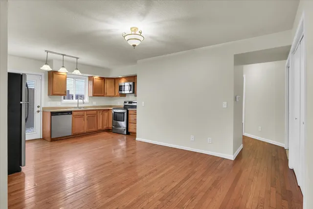 a view of kitchen with wooden floor electronic appliances and window