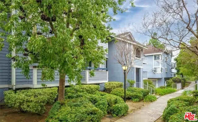 a front view of a house with a tree