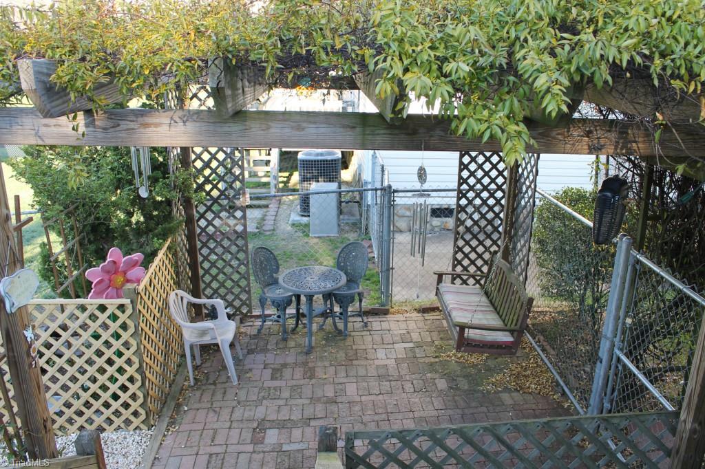 211 Albertson Road Thomasville, NC 27360 - Photo 13 of 18 Enjoy your brick patio with porch swing and vine covered trellis.