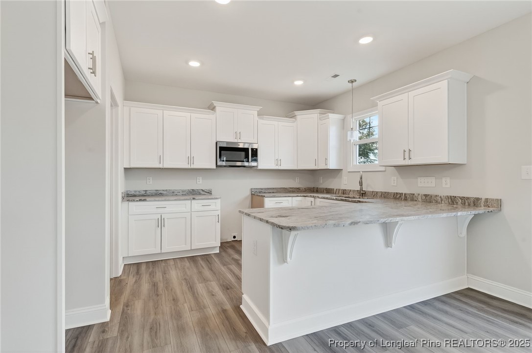 419 Delmore Road Autryville, NC 28318 - Photo 11 of 34 a kitchen with kitchen island granite countertop white cabinets and sink