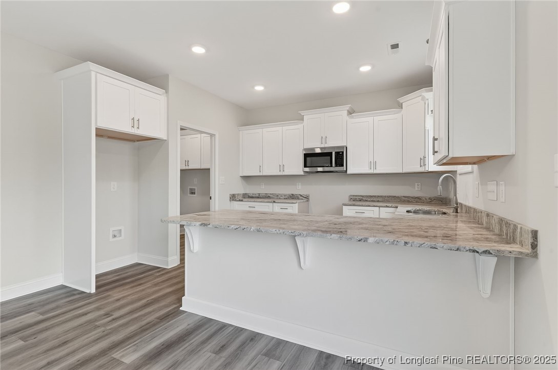 419 Delmore Road Autryville, NC 28318 - Photo 12 of 34 a kitchen with stainless steel appliances granite countertop a stove a sink and white cabinets
