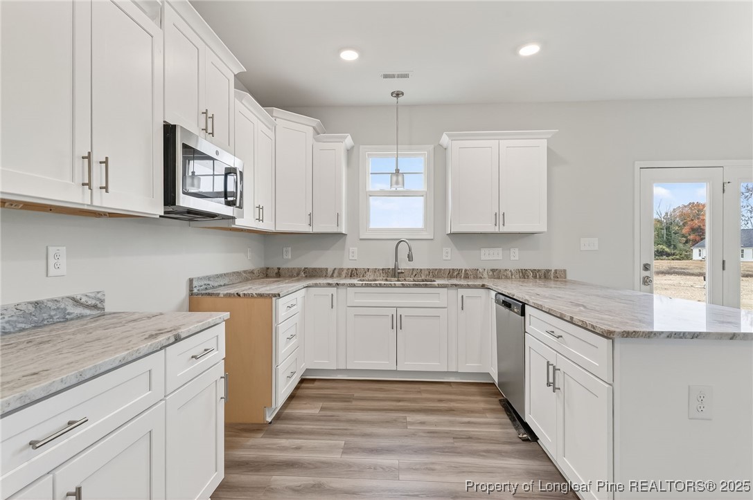 419 Delmore Road Autryville, NC 28318 - Photo 13 of 34 a kitchen with granite countertop white cabinets stainless steel appliances and a sink
