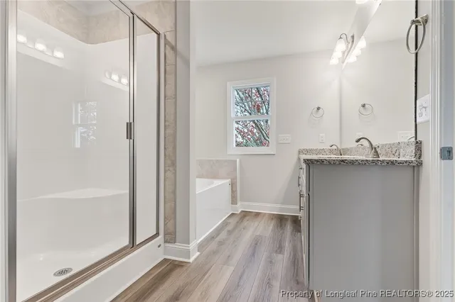 a bathroom with a granite countertop sink a mirror a vanity and a shower