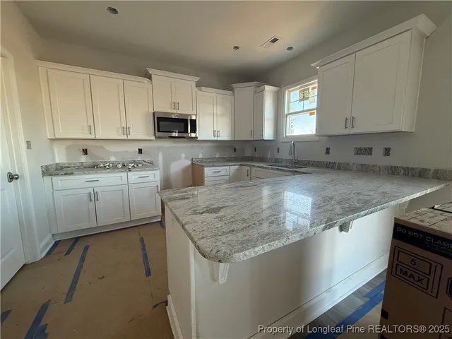 a kitchen with stainless steel appliances granite countertop a sink stove and cabinets