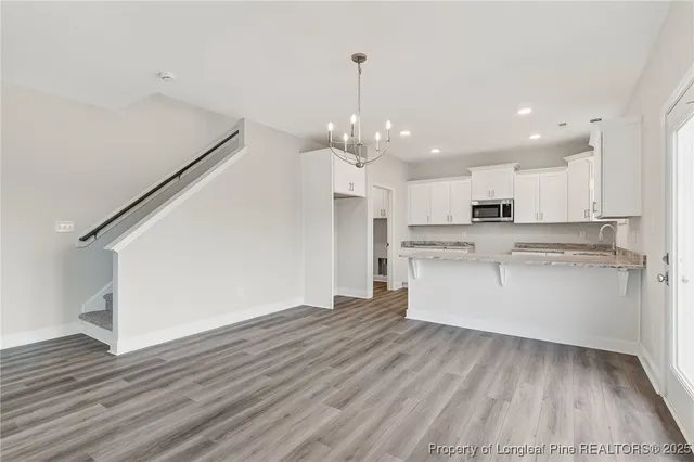 a view of kitchen with granite countertop cabinets and wooden floor