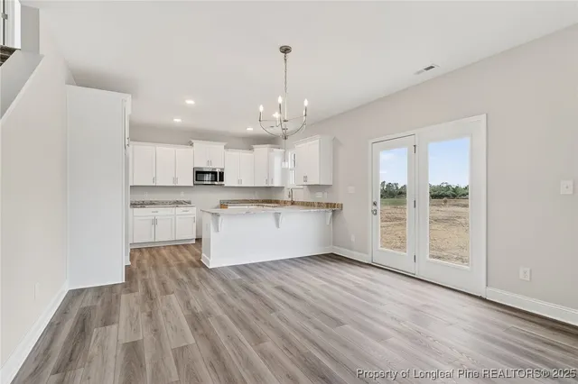 a view of kitchen with granite countertop cabinets and wooden floor