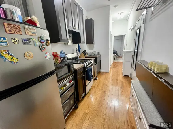a kitchen with stainless steel appliances a stove top oven a sink and a refrigerator