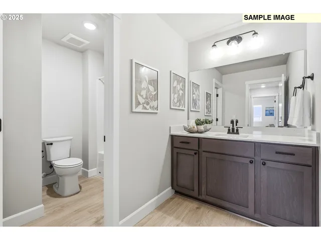 a bathroom with a sink vanity mirror and toilet