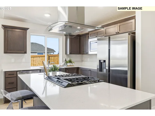 a kitchen with stainless steel appliances granite countertop a sink a stove a refrigerator and cabinets