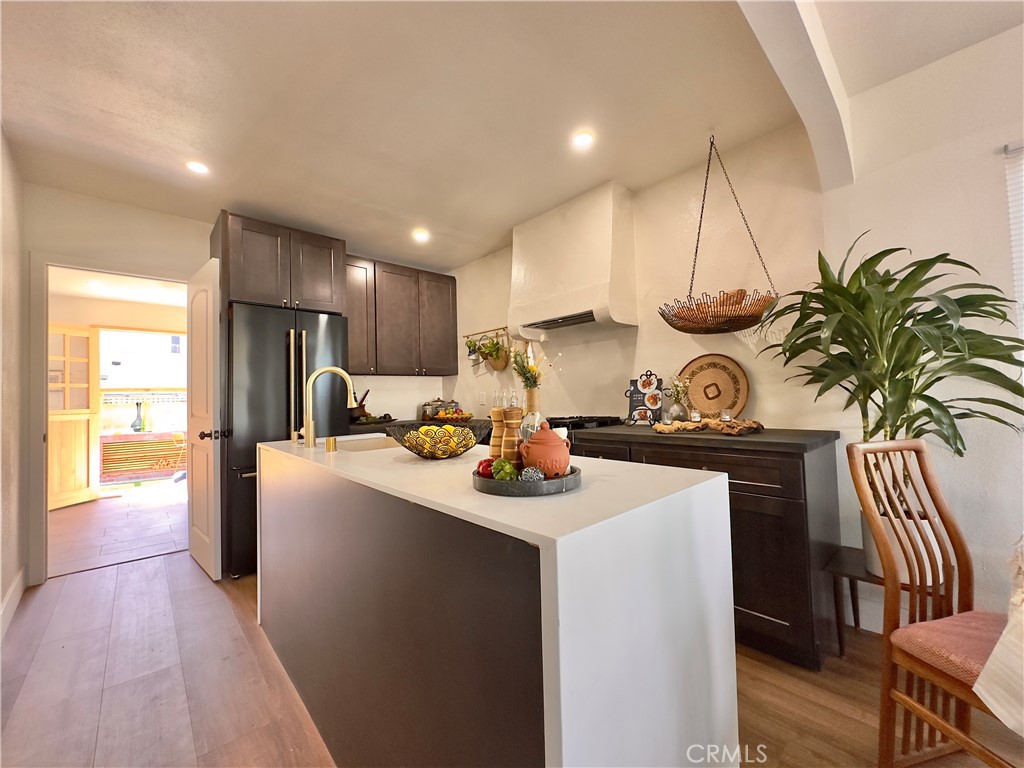 2907 South Ridgeley Drive Los Angeles, CA 90016 - Photo 19 of 37 a kitchen with stainless steel appliances kitchen island granite countertop a sink a stove and a wooden floors
