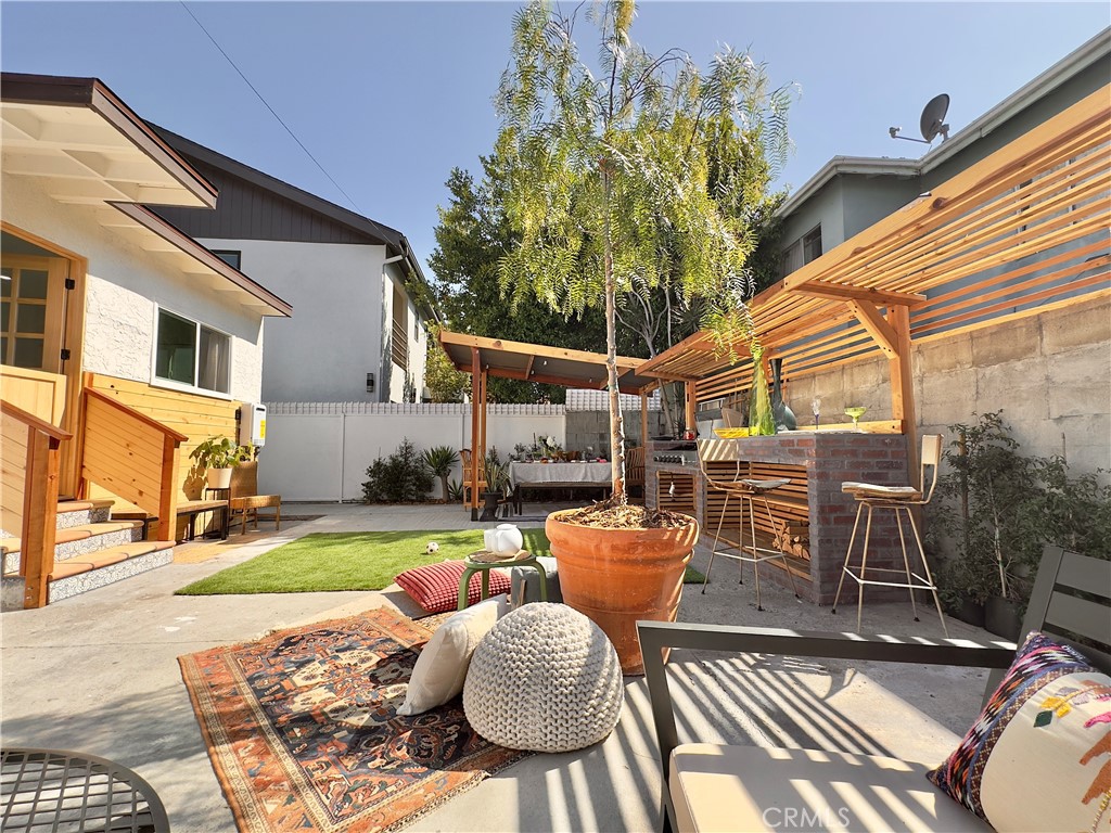 2907 South Ridgeley Drive Los Angeles, CA 90016 - Photo 35 of 37 a view of a patio with table and chairs potted plants and a palm tree