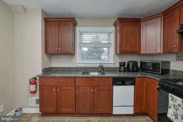 a kitchen with granite countertop a sink cabinets and window
