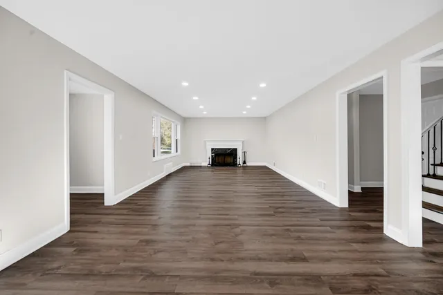 a view of a living room with wooden floor and a window