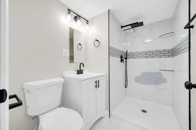 a bathroom with a shower a toilet and sink