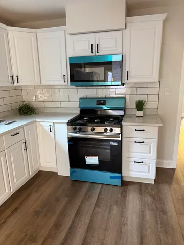 a kitchen with stainless steel appliances a stove a sink and a microwave