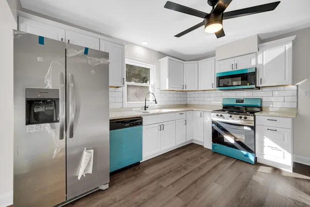 a kitchen with white cabinets and stainless steel appliances