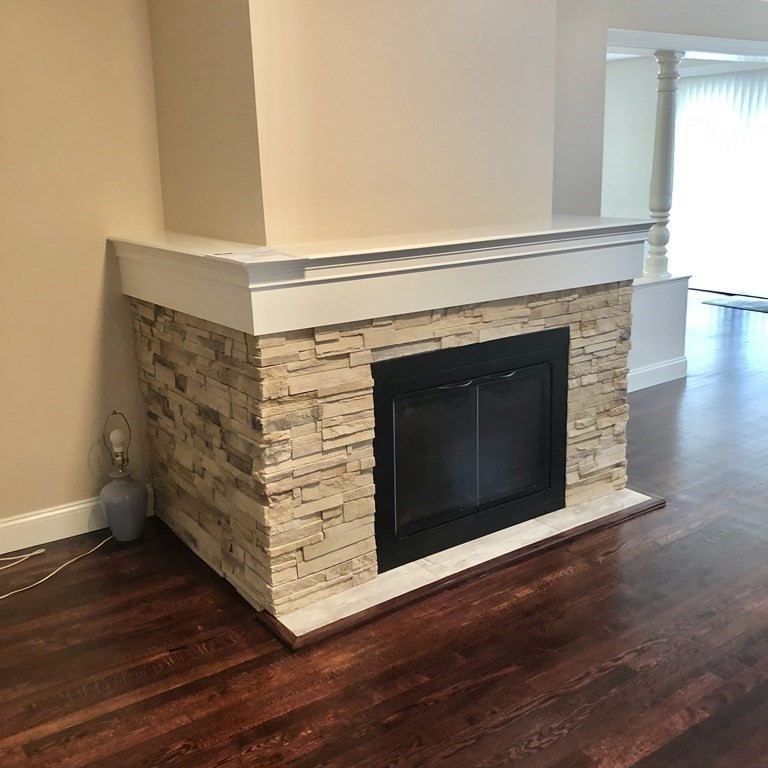 101 Parker Road Lancaster, MA 01523 - Photo 15 of 35 a view of an empty room with wooden floor and a fireplace