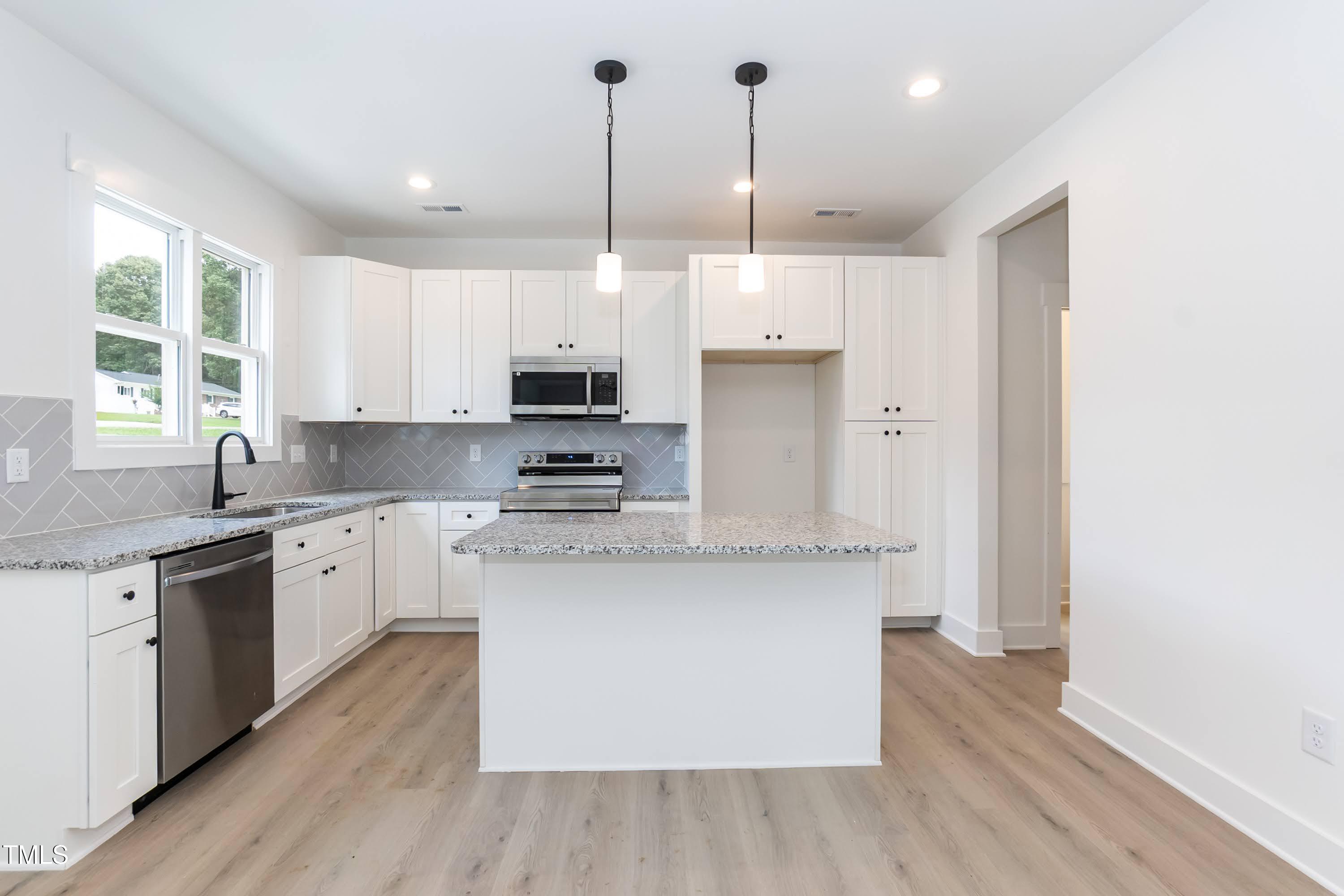 12 Gates Street Roxboro, NC 27573 - Photo 4 of 26 a kitchen with stainless steel appliances granite countertop a stove a sink dishwasher a refrigerator and white cabinets with wooden floor
