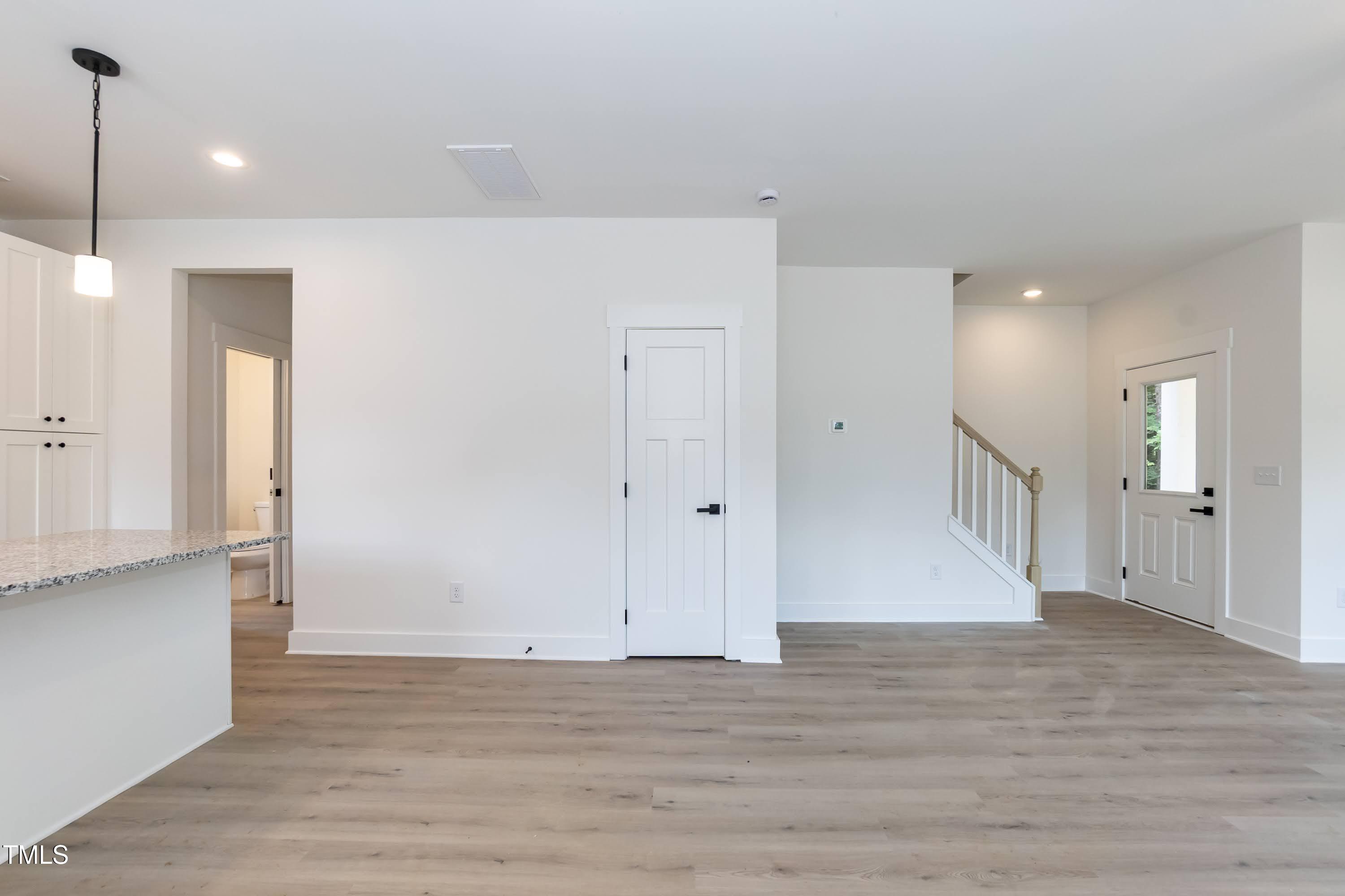 12 Gates Street Roxboro, NC 27573 - Photo 8 of 26 a view of an empty room with wooden floor and a ceiling fan