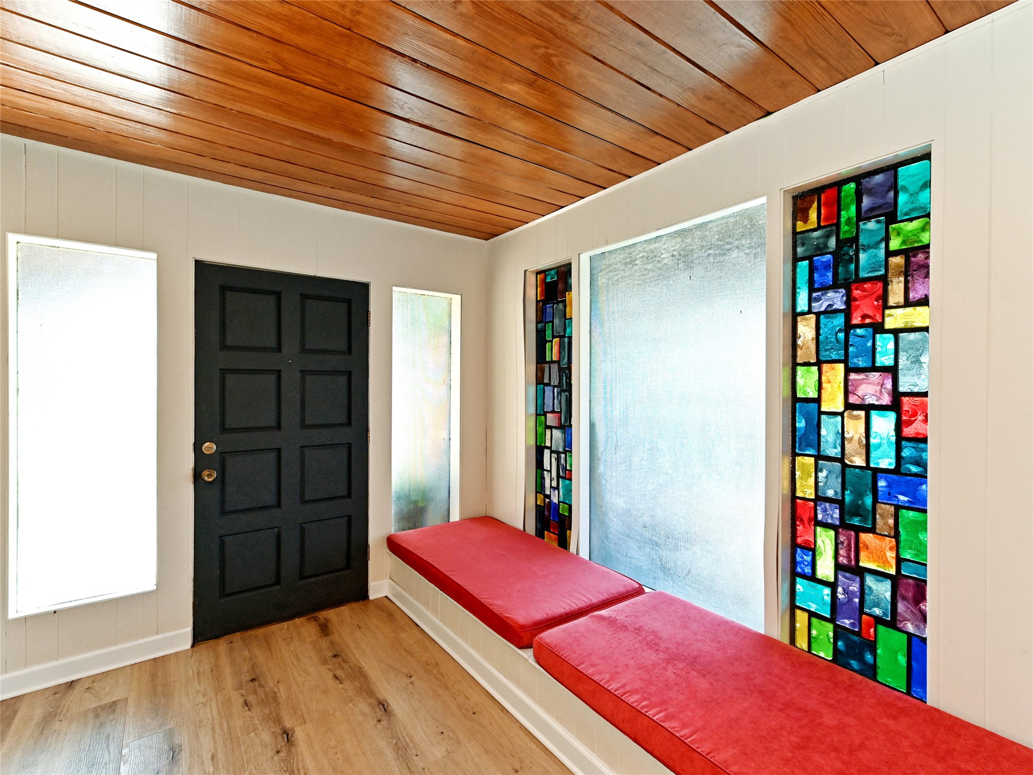 115 Snapper Street Lakeway, TX 78734 - Photo 3 of 30 Artistic stained glass windows and a vibrant cushioned bench welcome you into this inviting entryway.