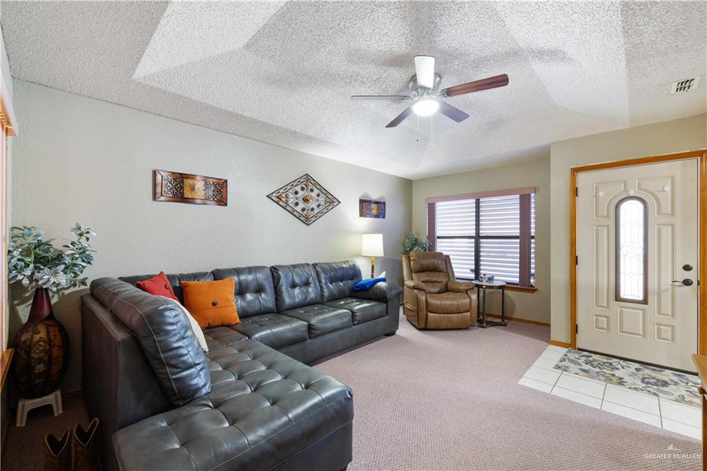 1804 Woodrow Street, Unit 184 Mission, TX 78572 - Photo 3 of 15 Tiled living room featuring carpet flooring, a textured ceiling, and a ceiling fan