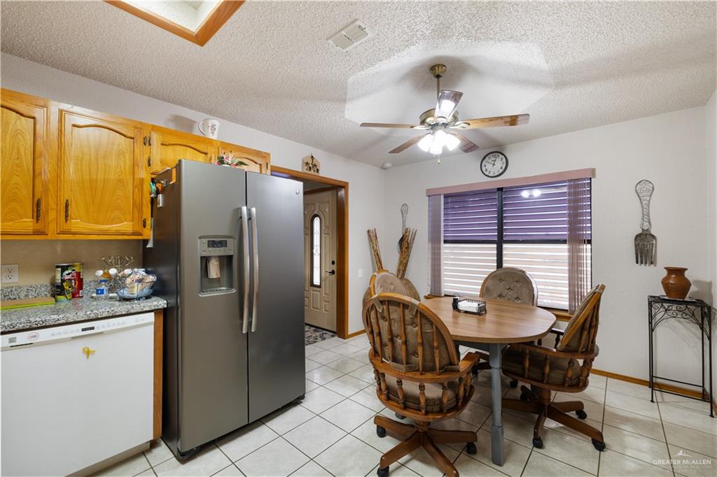 1804 Woodrow Street, Unit 184 Mission, TX 78572 - Photo 5 of 15 Dining space featuring a textured ceiling, light tile patterned floors, ceiling fan, and a skylight