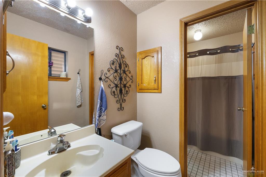 1804 Woodrow Street, Unit 184 Mission, TX 78572 - Photo 10 of 15 Bathroom with a textured ceiling, vanity, light tile patterned floors, and a textured wall