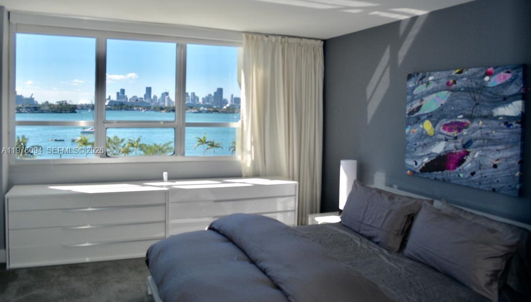 1500 Bay Road, Unit 524S Miami Beach, FL 33139 - Photo 12 of 27 a living room with a large window and a bed
