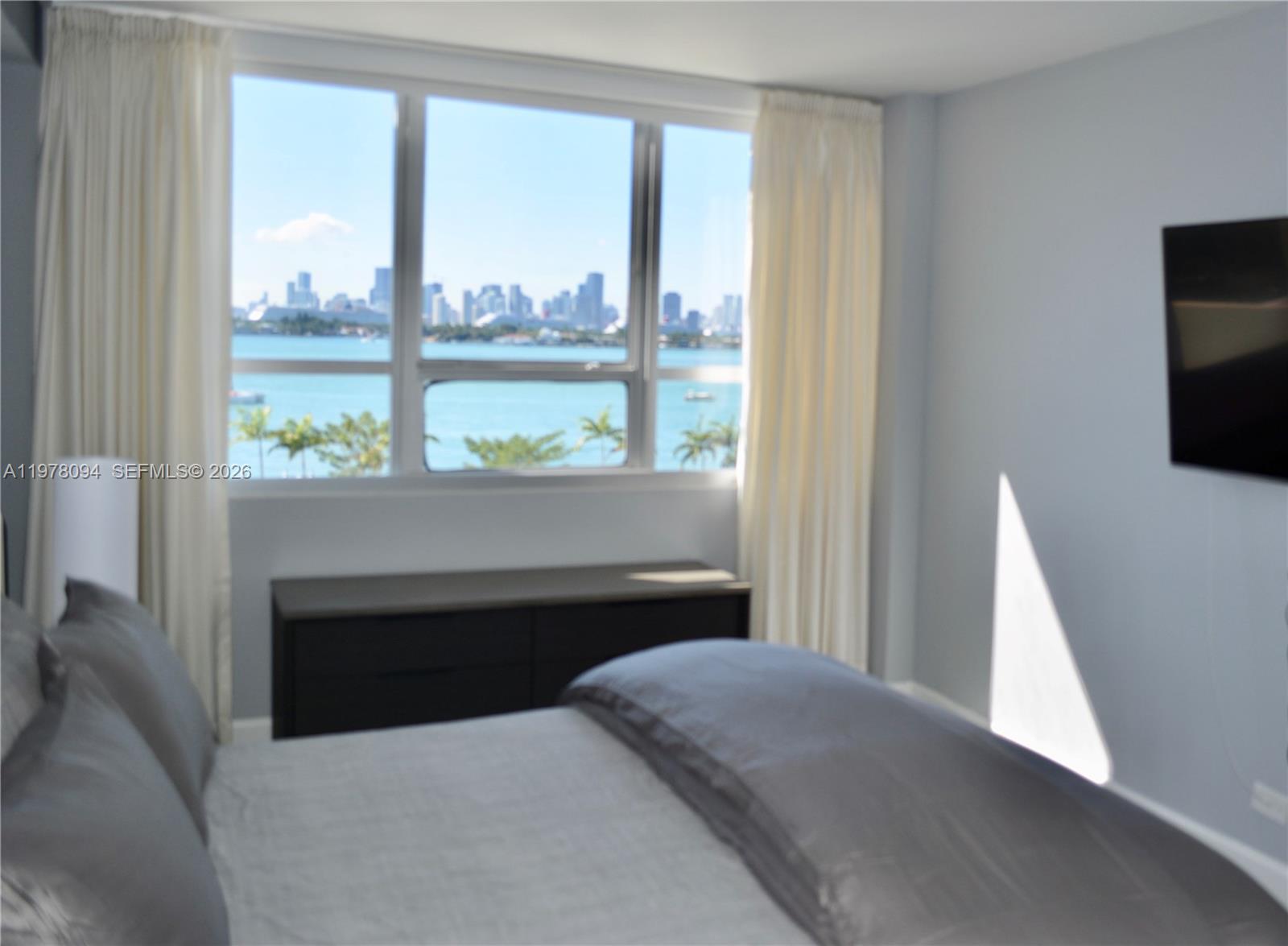 1500 Bay Road, Unit 524S Miami Beach, FL 33139 - Photo 13 of 27 a bedroom with a bed and large window