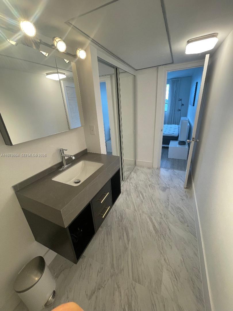 1500 Bay Road, Unit 524S Miami Beach, FL 33139 - Photo 9 of 27 a bathroom with a sink vanity and a mirror