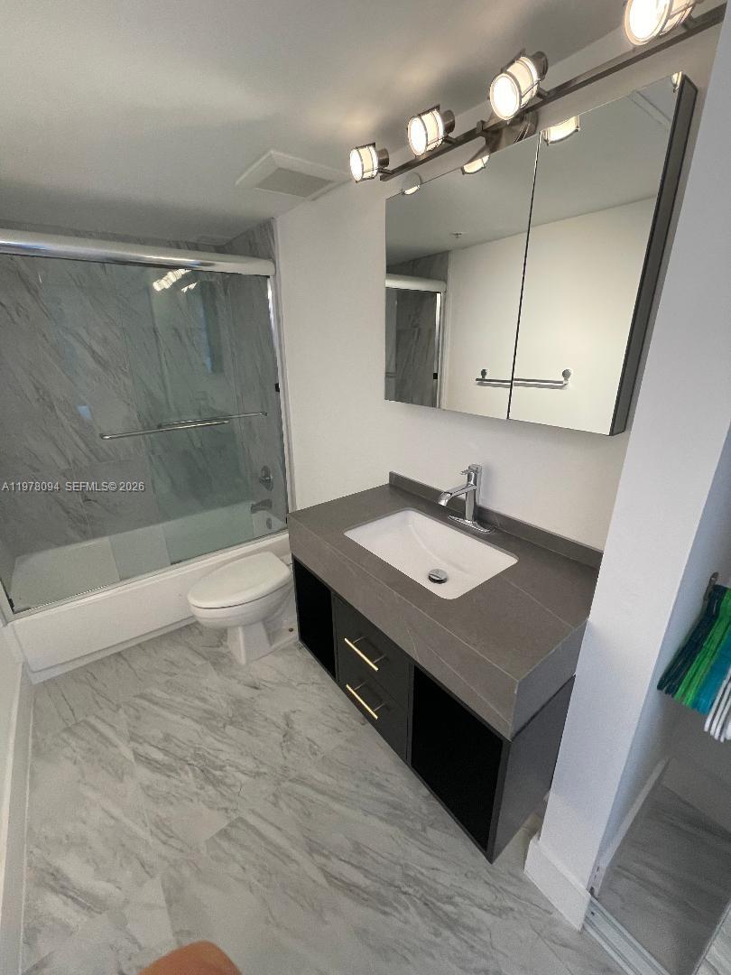 1500 Bay Road, Unit 524S Miami Beach, FL 33139 - Photo 10 of 27 a bathroom with a sink a toilet a mirror and shower