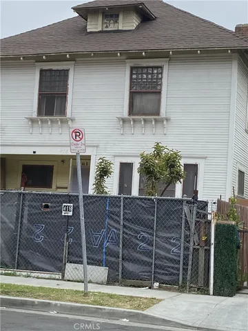 a view of a brick house with wooden fence