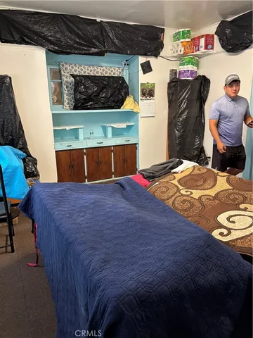 a bedroom with a bed a dresser and next to a window