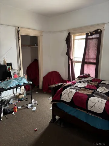 a bedroom with bed and a mirror