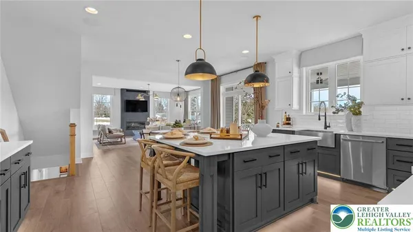 a kitchen with stainless steel appliances granite countertop a dining table and chairs with wooden floor