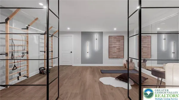a living room with furniture kitchen view and a wooden floor