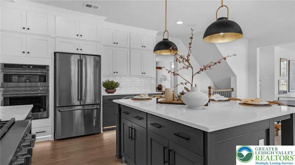 a kitchen with a stove a sink dishwasher a dining table and chairs with wooden floor