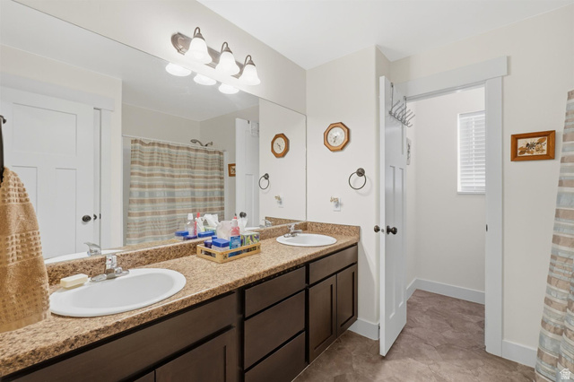 592 West 650 South Springville, UT 84663 - Photo 18 of 33 Double vanity with integrated sinks, granite-finish countertop, and dark wood cabinetry