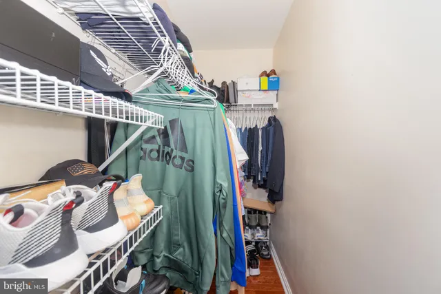 a view of walk in closet with clothes and shoes