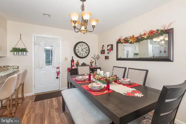a view of a dining room with furniture a chandelier and wooden floor