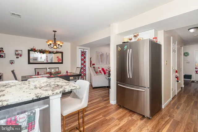 a kitchen with stainless steel appliances granite countertop a refrigerator and a stove top oven