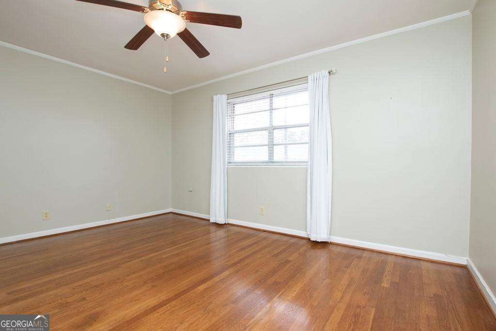 3660 Peachtree Road Northeast, Unit E7 Atlanta, GA 30319 - Photo 12 of 17 an empty room with wooden floor ceiling fan and windows