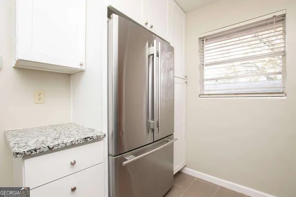 a view of a kitchen with a refrigerator and window