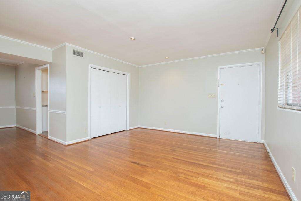 3660 Peachtree Road Northeast, Unit E7 Atlanta, GA 30319 - Photo 5 of 17 a view of an empty room with wooden floor and a window