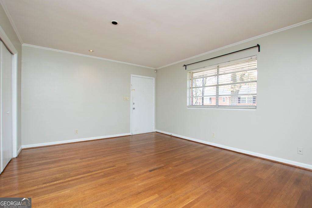 3660 Peachtree Road Northeast, Unit E7 Atlanta, GA 30319 - Photo 6 of 17 a view of an empty room with wooden floor and a window