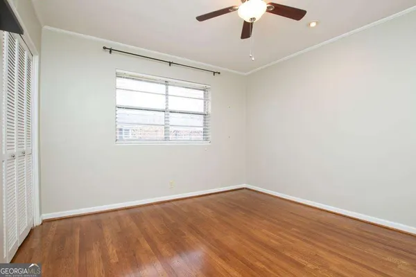 an empty room with a window and a ceiling fan